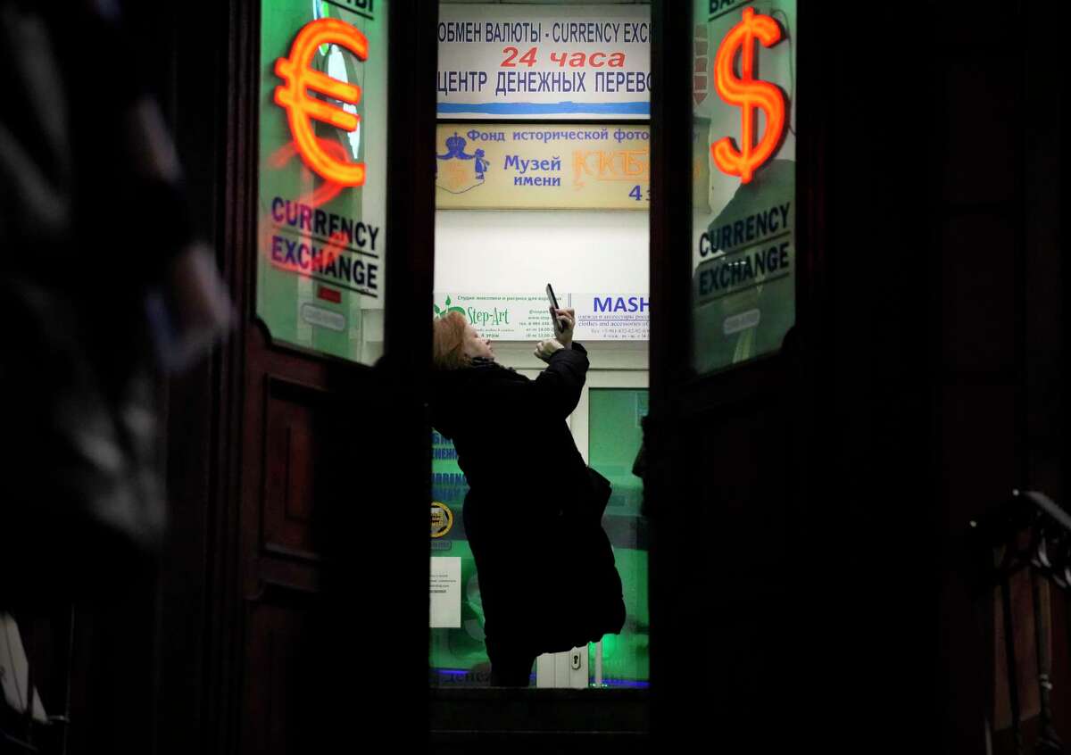 A woman stands in a currency exchange office in St. Petersburg, Russia, Friday, Feb. 25, 2022. Russians flocked to banks and ATMs on Thursday and Friday shortly after Russia launched an attack on Ukraine and the West announced crippling sanctions. According to Russia's Central Bank, on Thursday alone Russians have withdrawn 111 billion rubles (about $1.3 billion) in cash. (AP Photo/Dmitri Lovetsky)