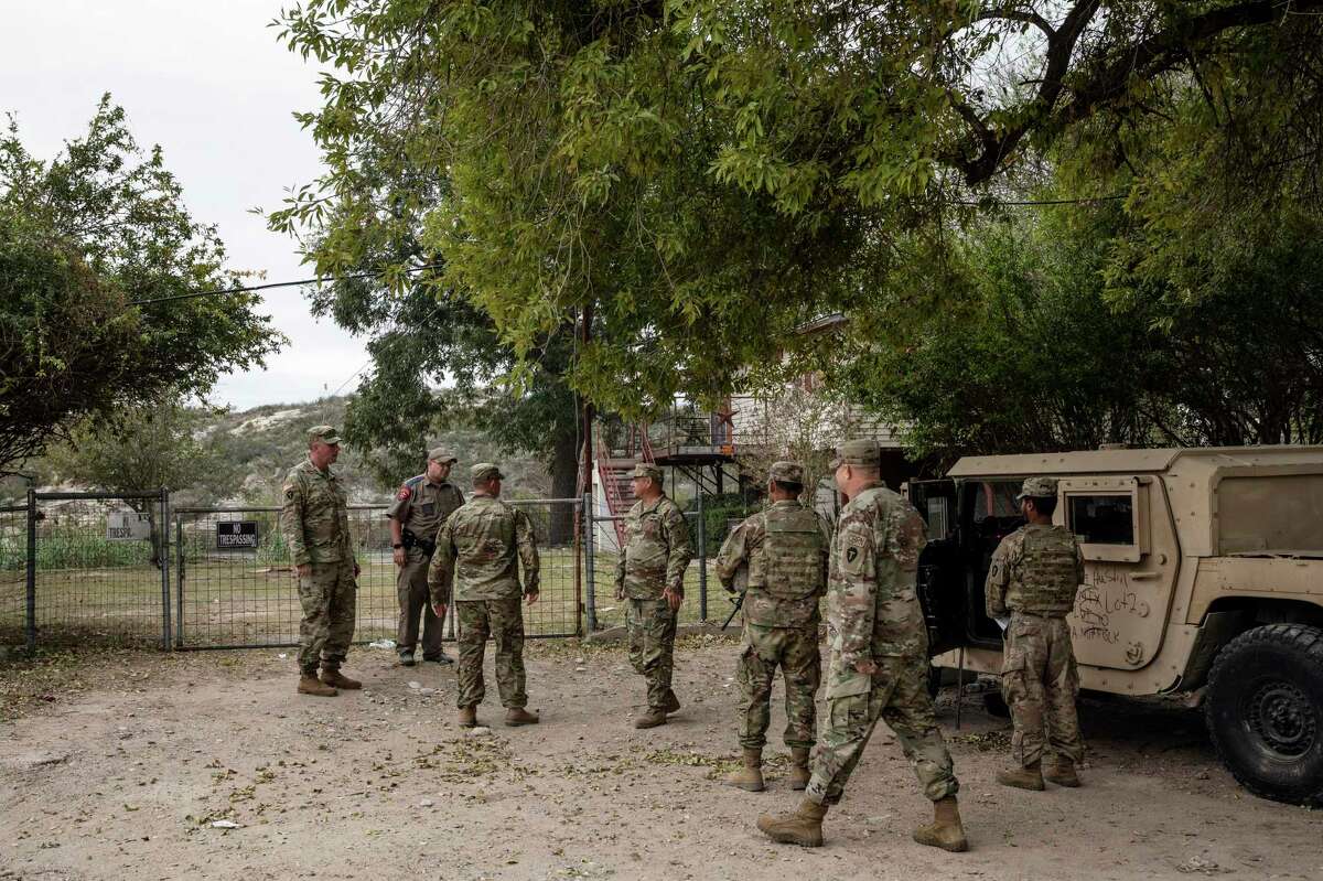 Members of the Texas Guard are stationed along the Rio Grande outside of Del Rio, Texas as part of Operation Lone Star on Nov. 18, 2021. Federal agents are not partnering with Texas state police in making trespassing arrests. (Kirsten Luce/The New York Times)