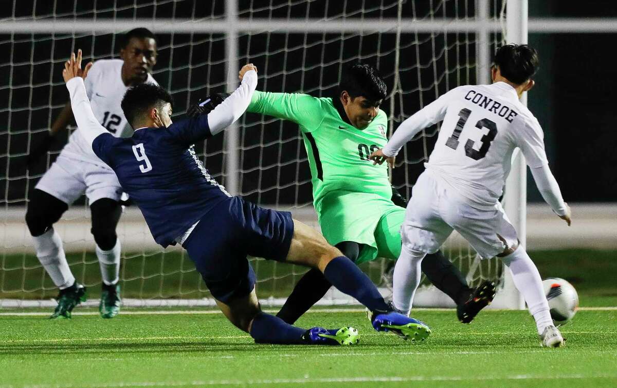 Conroe goalie Melvan Maldonado (00) makes a stop against College Park’s Gabryel Marques (9) in the first period of a District 13-6A high school soccer match at Woodforest Bank Stadium, Tuesday, March 8, 2022, in Shenandoah.