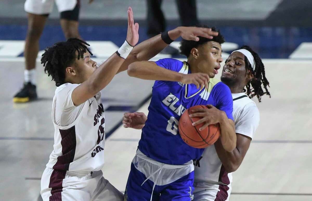 Elkins' Chris Johnson (0) tries to make a pass while Summer Creek players are defensing him during the fourth quarter of a UIL 6A Region III Boys Basketball Playoffs Semifinal game Tuesday, March 2, 2021, at Delmar Fieldhouse in Houston.