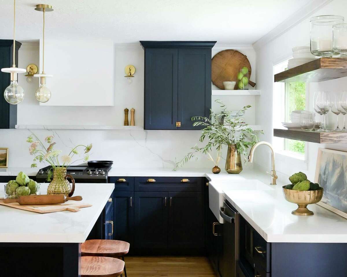 In the kitchen, the Clapps removed a peninsula and pony wall to open it up and accommodate an island. Krissy Clapp loved deeper, richer tones and chose Benjamin Moore’s Polo blue with brass hardware for the cabinets.