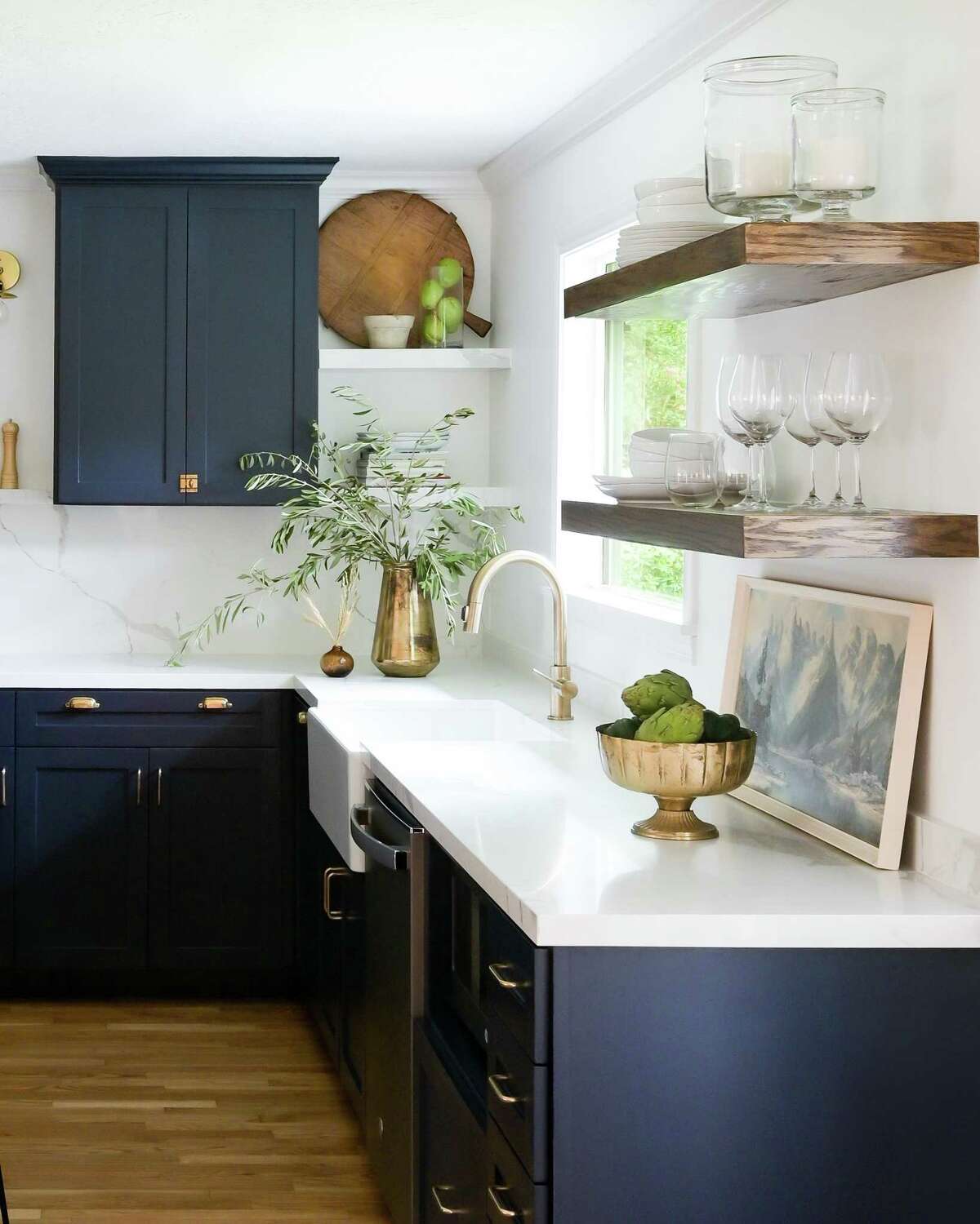 In the kitchen, the Clapps removed a peninsula and pony wall to open it up and accommodate an island. Krissy Clapp loved deeper, richer tones and chose Benjamin Moore’s Polo blue with brass hardware for the cabinets.