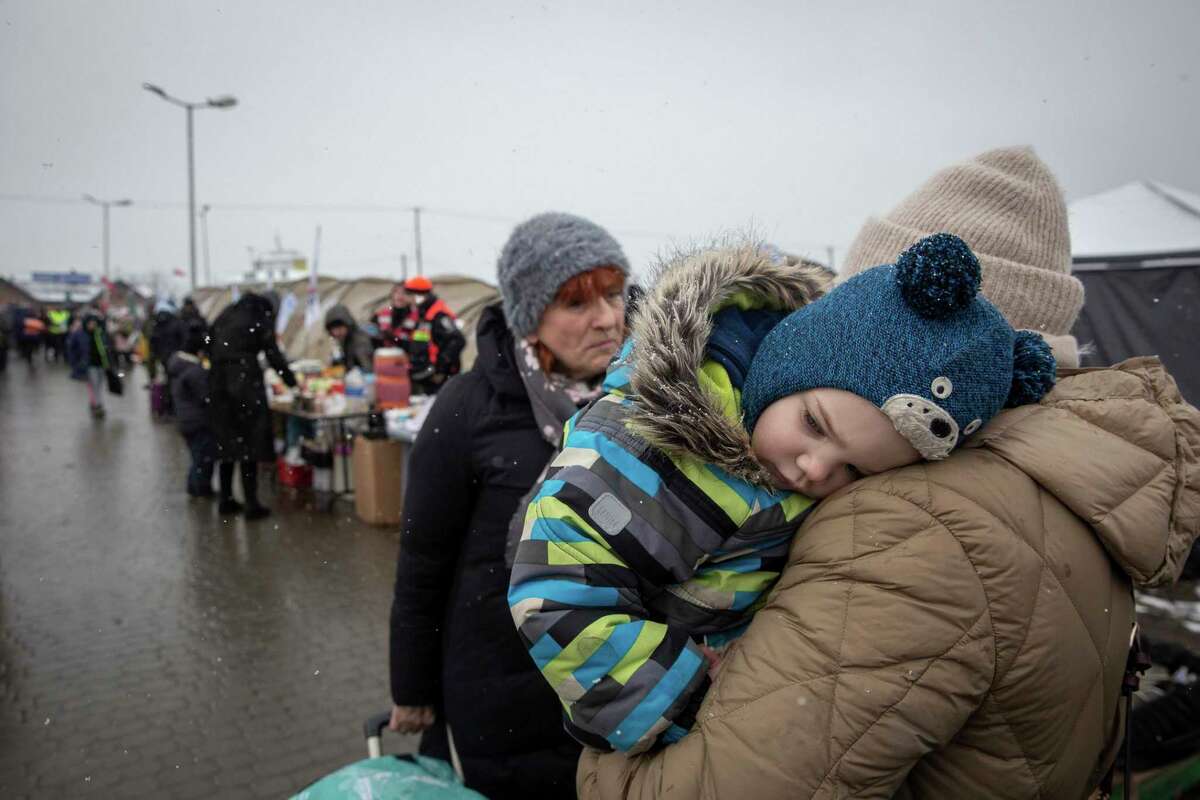 A boy rest his head on his mother's shoulder after fleeing from Ukraine, at the border crossing in Medyka, Poland, Wednesday, March 9, 2022. U.N. officials said that the Russian onslaught has forced 2 million people to flee Ukraine. It has trapped others inside besieged cities that are running low on food, water and medicine amid the biggest ground war in Europe since World War II.