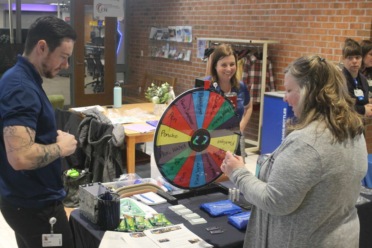 Rochelle Boes, WSCC director of nursing and Allied Health (right), checks out the prize wheel at Munson Healthcare Manistee Hospital's booth during a nursing career day on Wednesday.