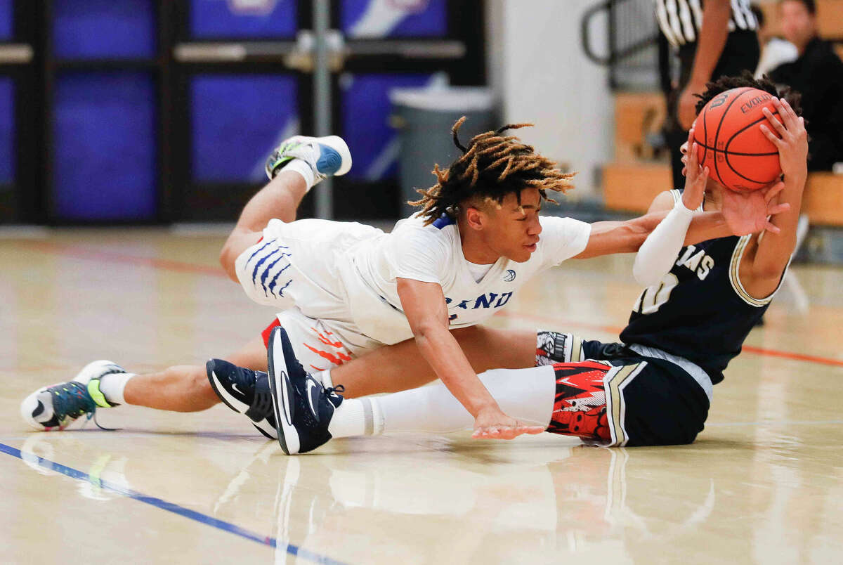Grand Oaks point guard Jordan Reece (3) stretches for a loose ball against Klein Collins point guard Greg Jackson III (10) in the first quarter of a game during the Beast Up invitational at Grand Oaks High School, Saturday, Dec. 4, 2021, in Spring.