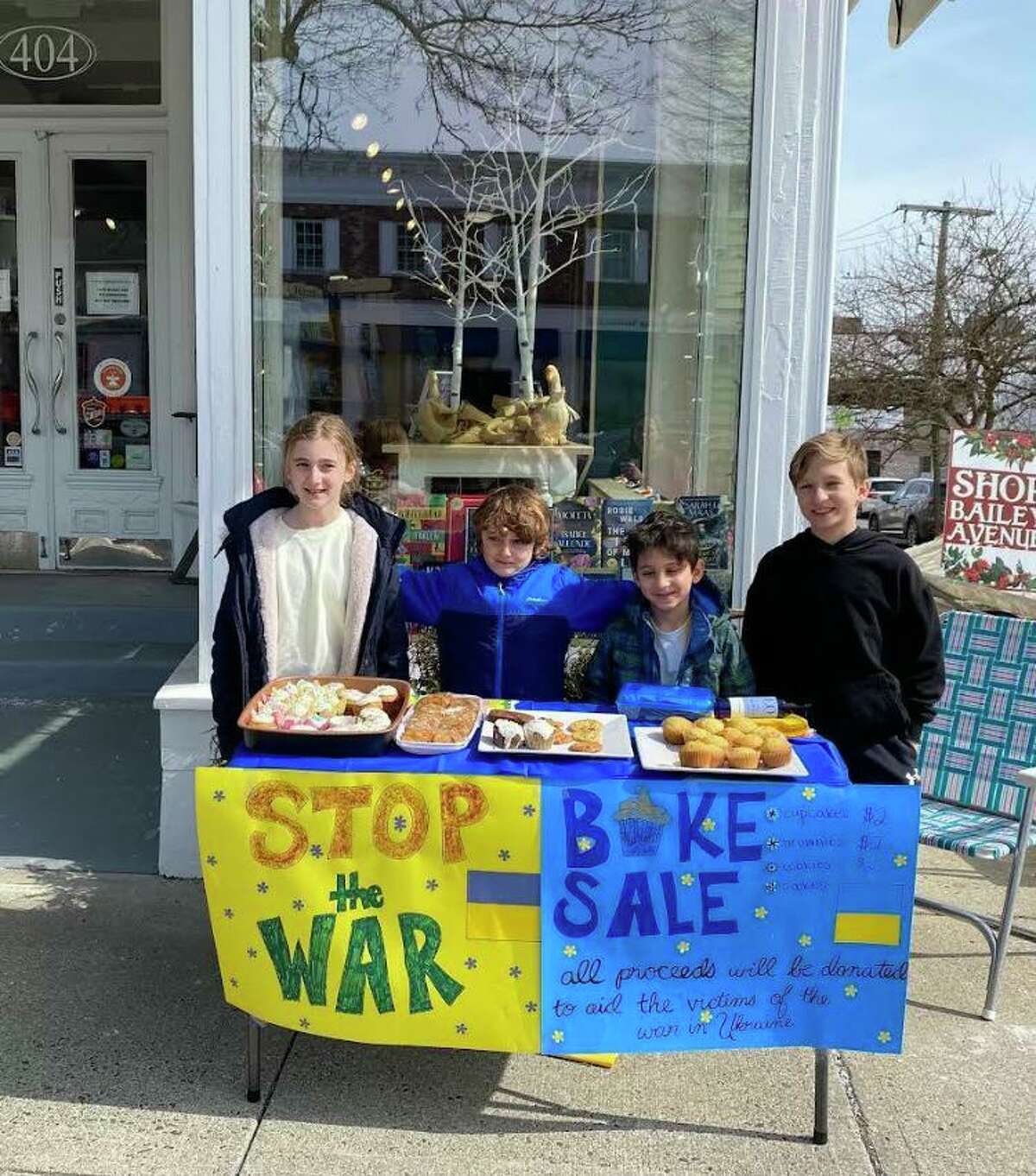 Viktoria Berisha, left, Jozef Berisha, Oliver Potter and Ian Potter, of South Salem, N.Y., held a bake sale in front of Books on the Common to benefit relief efforts in Ukraine. They raised more than $600.