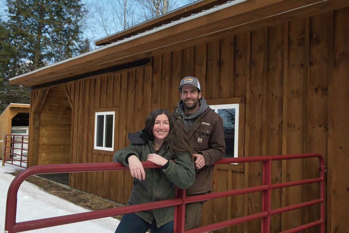 Darcie and Mark Burroughs, who run the construction company, Steel Pines, pose for a photo outside a horse barn on their property on Tuesday, March 8, 2022, in Edinburg, N.Y.