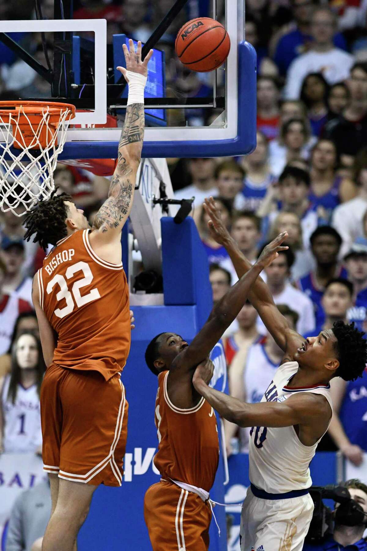 Texas forward Christian Bishop (32) tries to block a shot by Kansas guard Ochai Agbaji during the Longhorns’ overtime loss to the Jayhawks on Saturday.