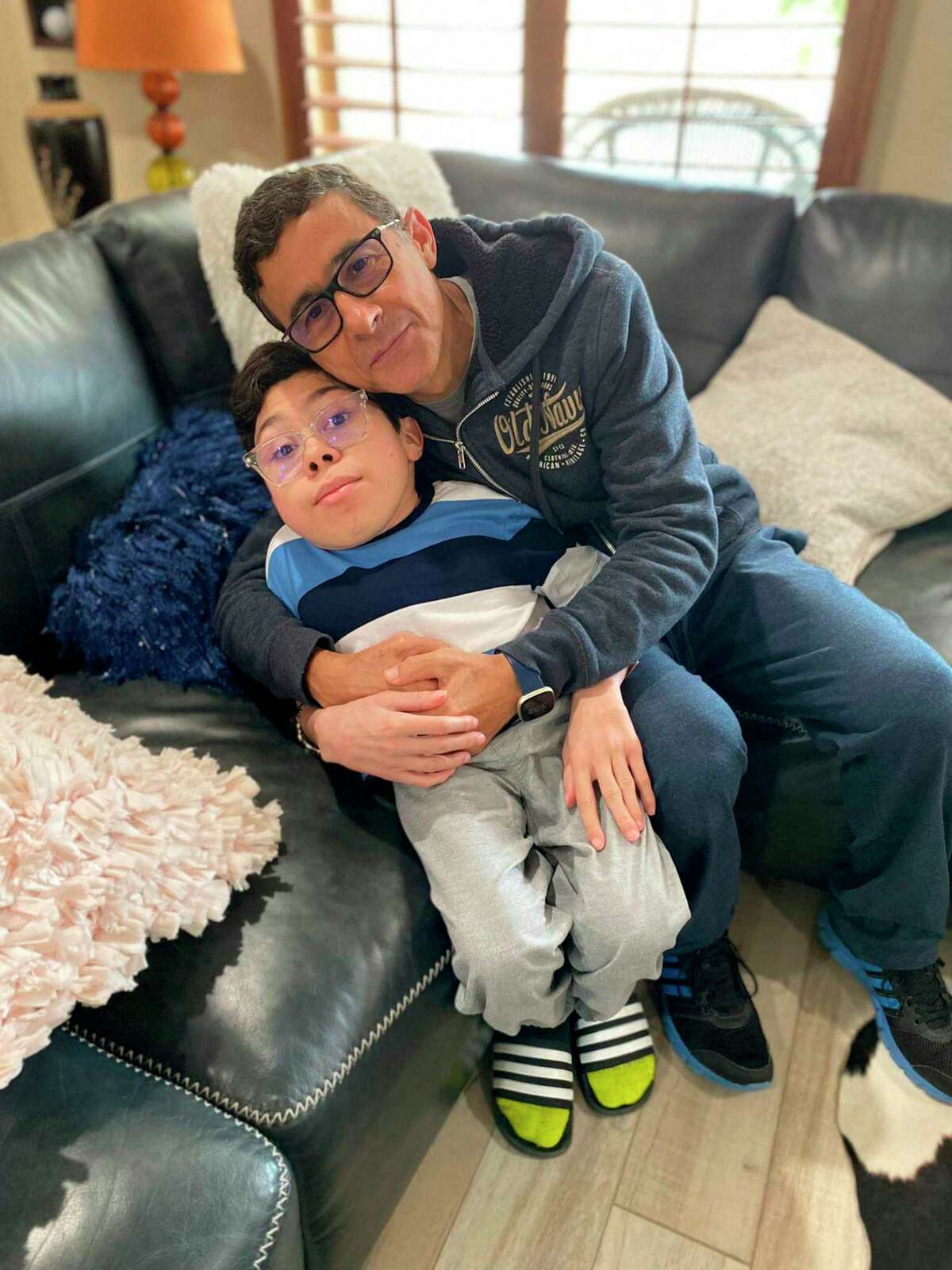 In this handout photo provided by Maria Elena Cardenas, Gustavo Cardenas, one of six oil executives jailed in Venezuela, poses for a photo with his son Sergio, in their home in Houston, Wednesday, March 9, 2022. Cardenas expressed happiness to be home after an imprisonment of more than four years that he said “has caused a lot of suffering and pain, much more than I can explain with my words.” But he said he is praying for five colleagues of his company who were not released Tuesday night. Together, the men are known as the “Citgo 6.” (Maria Elena Cardenas via AP)