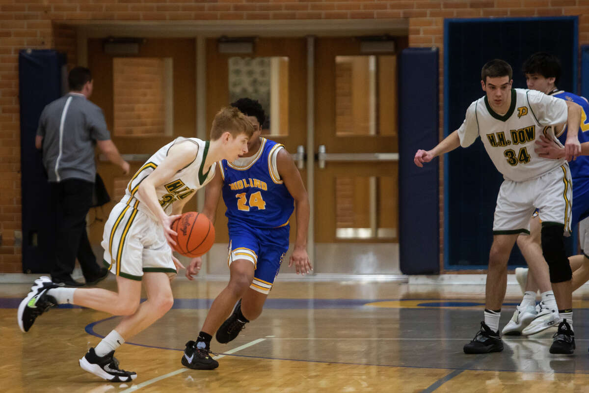 Dow's Nick Bond dribbles down the court while Midland's Jason Davenport guards him during the Chemics' district semifinal victory Wednesday, March 9, 2022 at Midland High School.