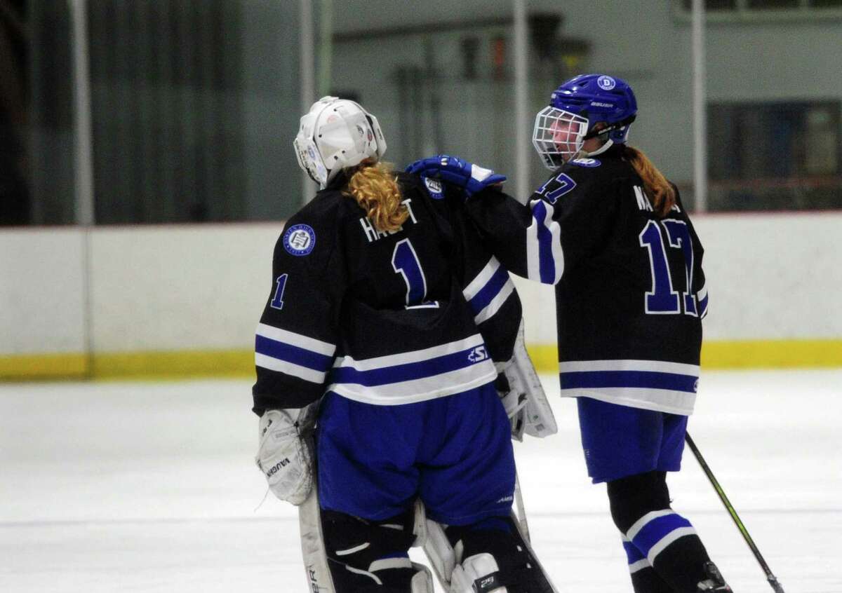 Darien's Morgan Massey (17), right, consoles goalie Claire Haupt (1) after the team was defeated by New Canaan in Connecticut High School Girls Hockey Association state final action at Darien Ice House in Darien, Conn., on Saturday March 9, 2022. New Canaan broke the 3-3 tie in triple overtime.