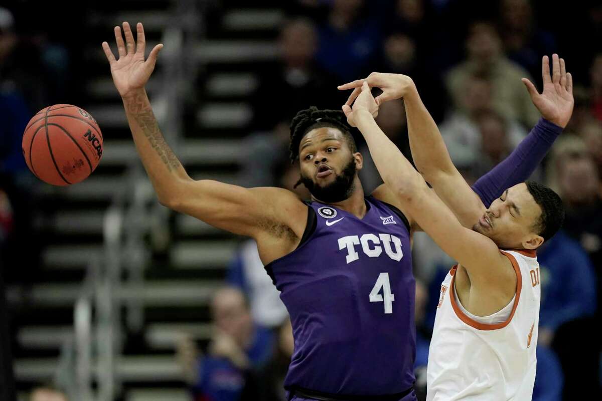 TCU center Eddie Lampkin (4) deflects a pass by Texas forward Dylan Disu, right, during the first half of an NCAA college basketball game in the quarterfinal round of the Big 12 Conference tournament in Kansas City, Mo., Thursday, March 10, 2022. (AP Photo/Charlie Riedel)