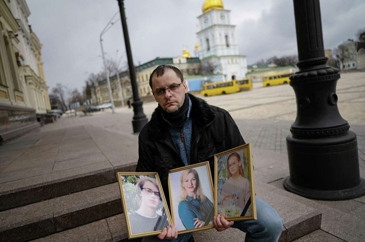 Sergii Perebeinis holds portraits of his wife, Tatiana, and children Nikita, 18, and Alise, 9, who were killed by Russian mortar fire as they tried to evacuate two days earlier, in Kyiv, Ukraine.