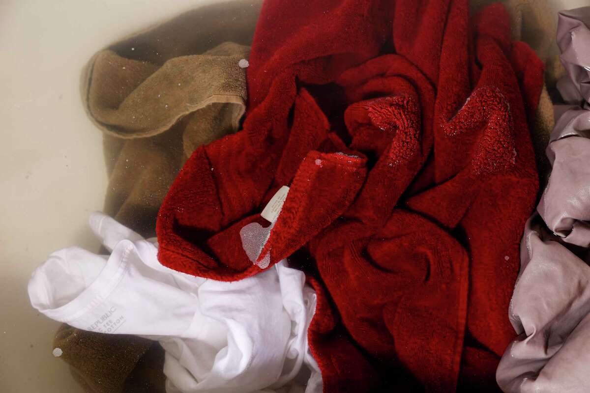 Laundry stripping is a do-it-yourself life hack during which seemingly clean laundry — like the T-shirt, towels and bed sheets seen here — soaks in a tub of hot water, getting deep cleaned while turning the water a horrifyingly murky brownish-gray.