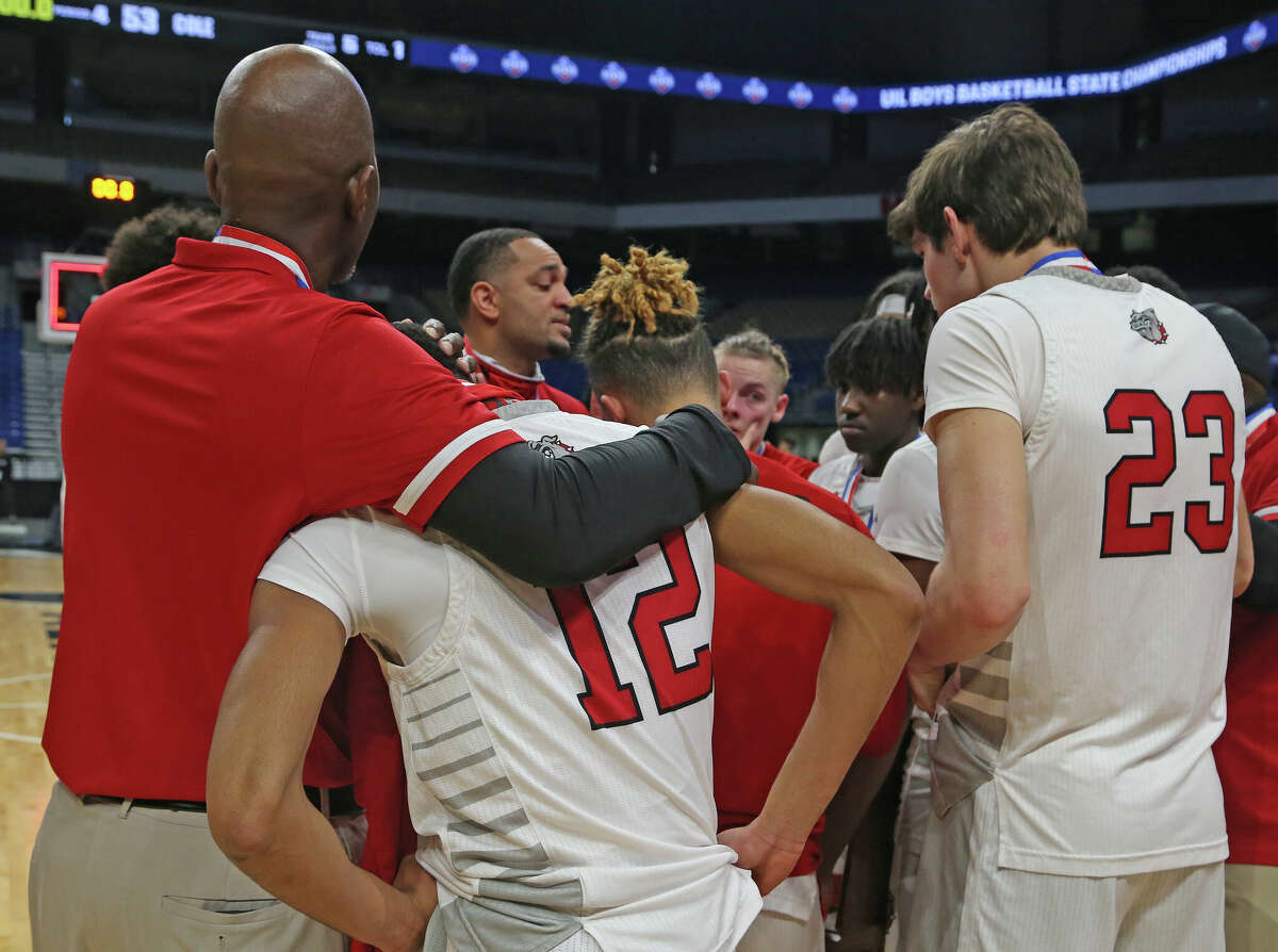 As Hitchock head coach Christopher Jordan-Foster speaks to the team guard AâAderius Blanks (12) is comforted. In UIL state boys basketball tournament Class 3A semifinal San Antonio Cole defeated Hitchock 53-49 on Thursday, March 10, 2022 at the Alamodome.