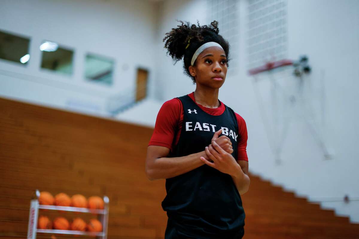 Zhane Duckett, 21, a sophomore point guard for Cal State East Bay's women's basketball team, stands in a circle with her teammates during practice at Pioneer Gym on Wednesday, March 9, 2022, in Hayward, Calif. Duckett, who's from Oakland and starred at St. Joseph Notre Dame High School in Alameda, lost her mother, Kimberly Duckett, to breast cancer at the start of the season. Playing to honor her mother's memory, Duckett - an all-conference selection - has guided the Pioneers to their best record in program history.