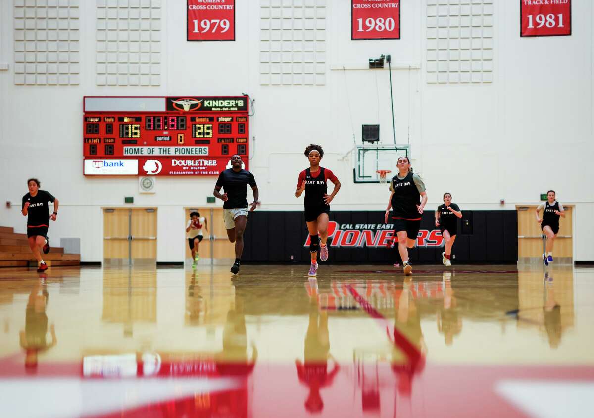 Zhane Duckett, 21, center, a sophomore point guard for Cal State East Bay's women's basketball team, run a drill with her teammates during practice at Pioneer Gym on Wednesday, March 9, 2022, in Hayward, Calif. Duckett, who's from Oakland and starred at St. Joseph Notre Dame High School in Alameda, lost her mother, Kimberly Duckett, to breast cancer at the start of the season. Playing to honor her mother's memory, Duckett - an all-conference selection - has guided the Pioneers to their best record in program history.