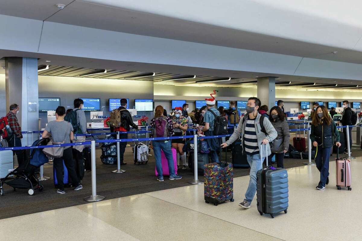 Passengers wait in line at the United Airlines check-in counters at San Francisco International Airport.