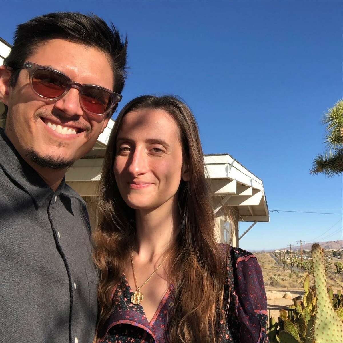 Alexander Aquino-Kaljakin and his wife, Che Hurley, in front of their Yucca Valley home after they received the keys.