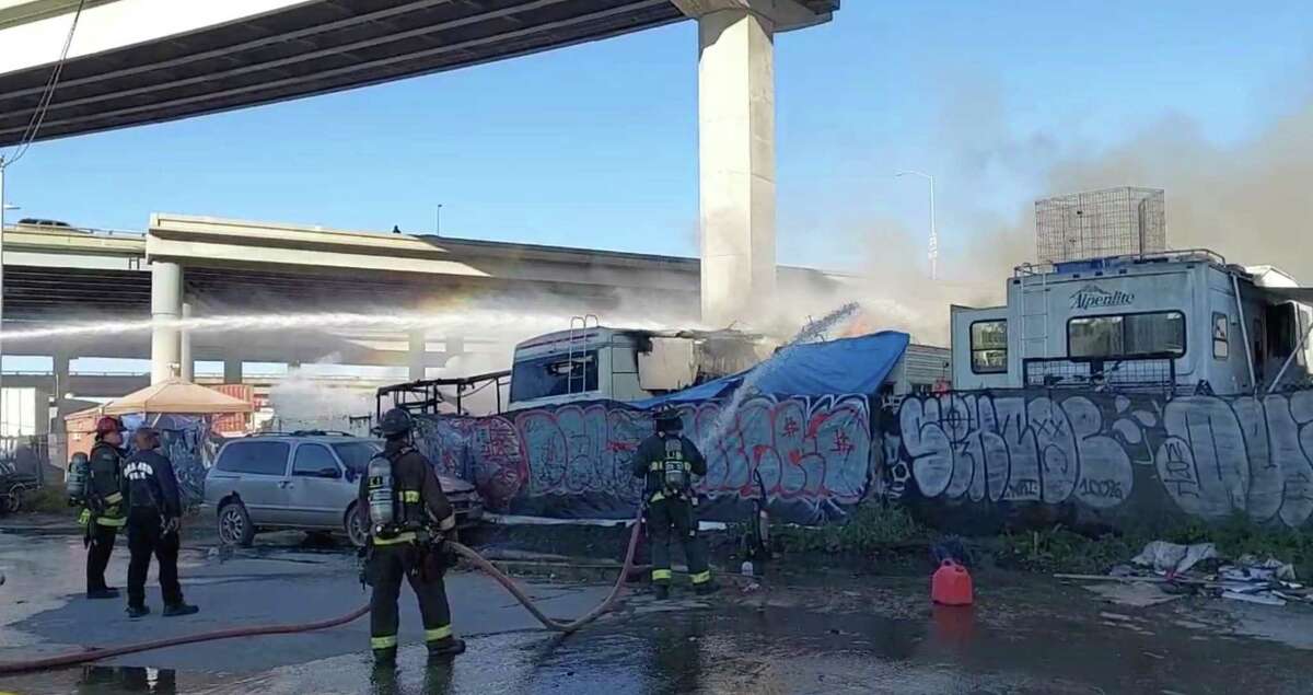 Oakland firefighters battle a blaze at a city sanctioned RV parking lot near 34th and Wood Streets on Thursday, May 10, 2022.