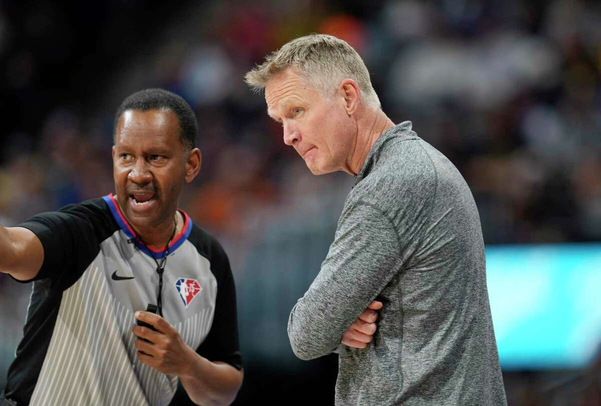 Golden State Warriors coach Steve Kerr confers with referee James Capers during the first half of the team's NBA basketball game against the Denver Nuggets on Thursday, March 10, 2022, in Denver. (AP Photo/David Zalubowski)