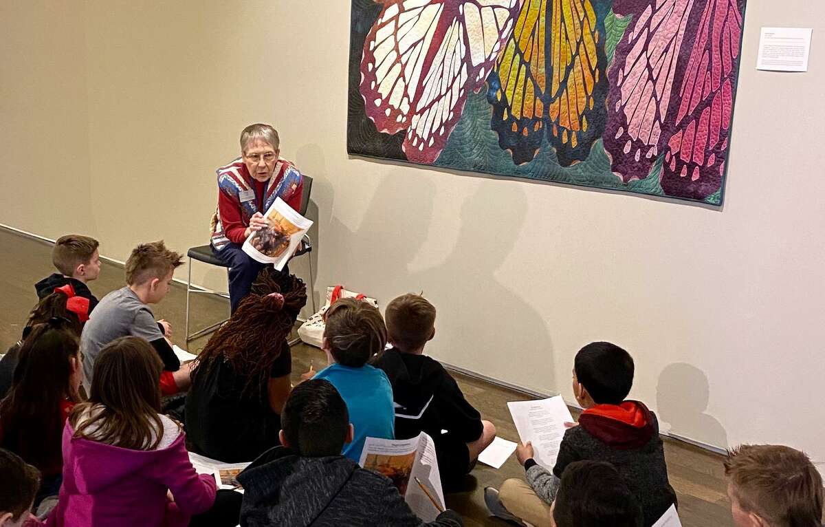 A docent tells visitors about works of art on display at the Pearl Fincher Museum of Fine Arts.