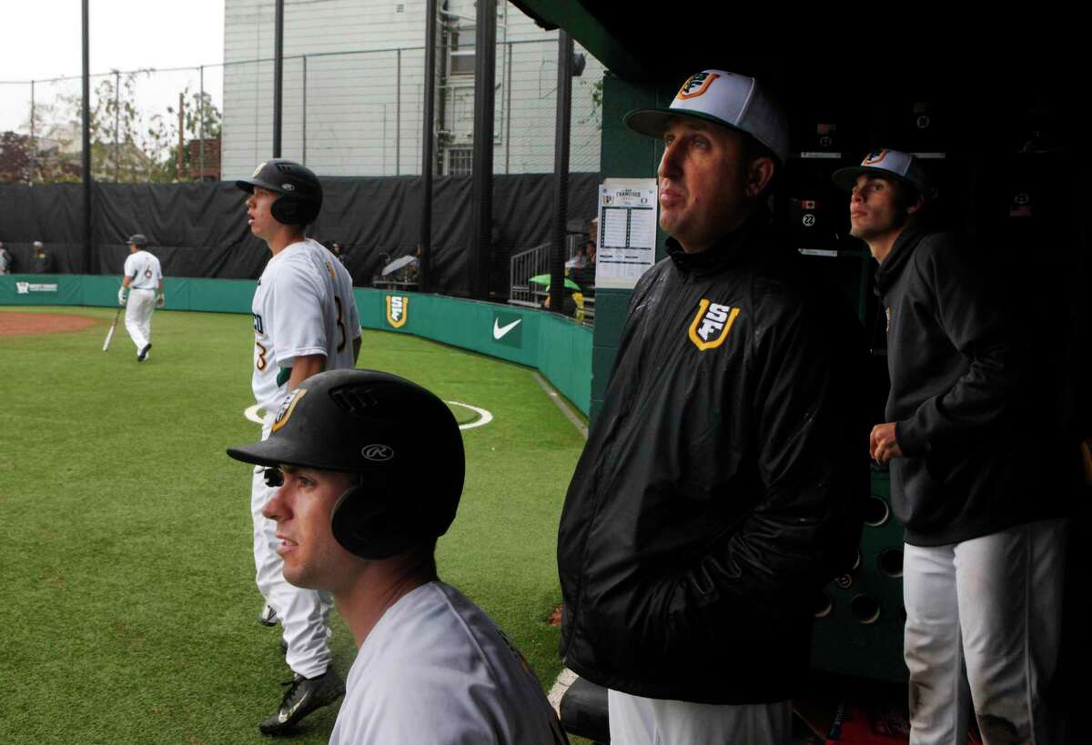 Longtime head coach Nino Giarratano (second from right) watches a home run fly over the fence with players (clockwise from bottom) Zack Turner, Derek Atkinson and Devon Loomis during a game against Oregon as his son Nico walks up for his turn to bat at Dante Benedetti Diamond at Max Ulrich Field in San Francisco on March 25, 2014.