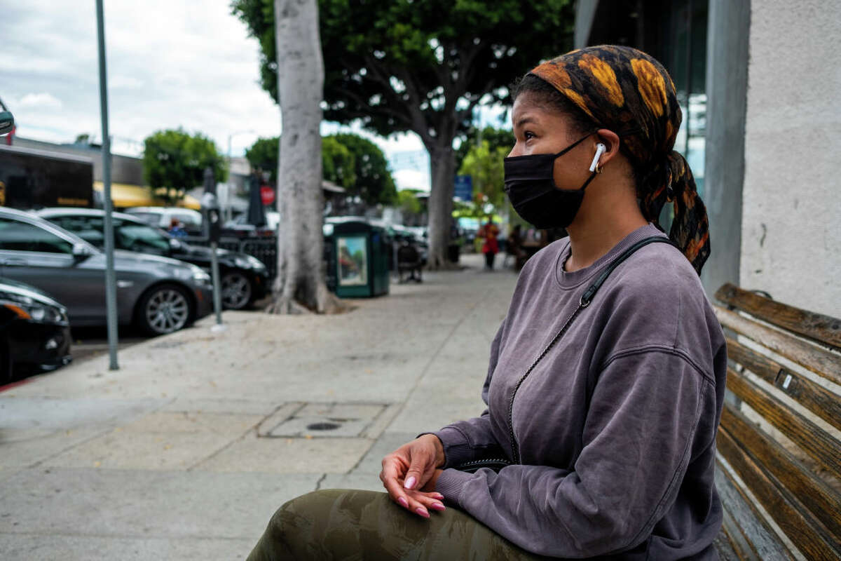 Marlo Thomas, 35, is wearing a mask as she waits for her Uber Friday, March 4, 2022 in Larchmont Village, neighborhood of Los Angeles. (Francine Orr / Los Angeles Times via Getty Images)