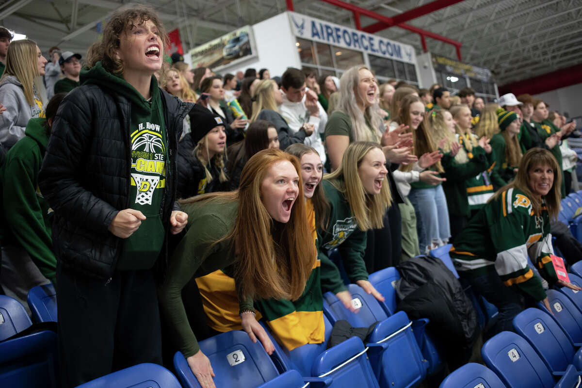 Kennedy Caldwell, left, and Alexa Kolnitys, second from left, cheer during the final moments of Dow's state semifinal victory over Calumet Friday, March 11, 2022 at USA Hockey Arena in Plymouth.