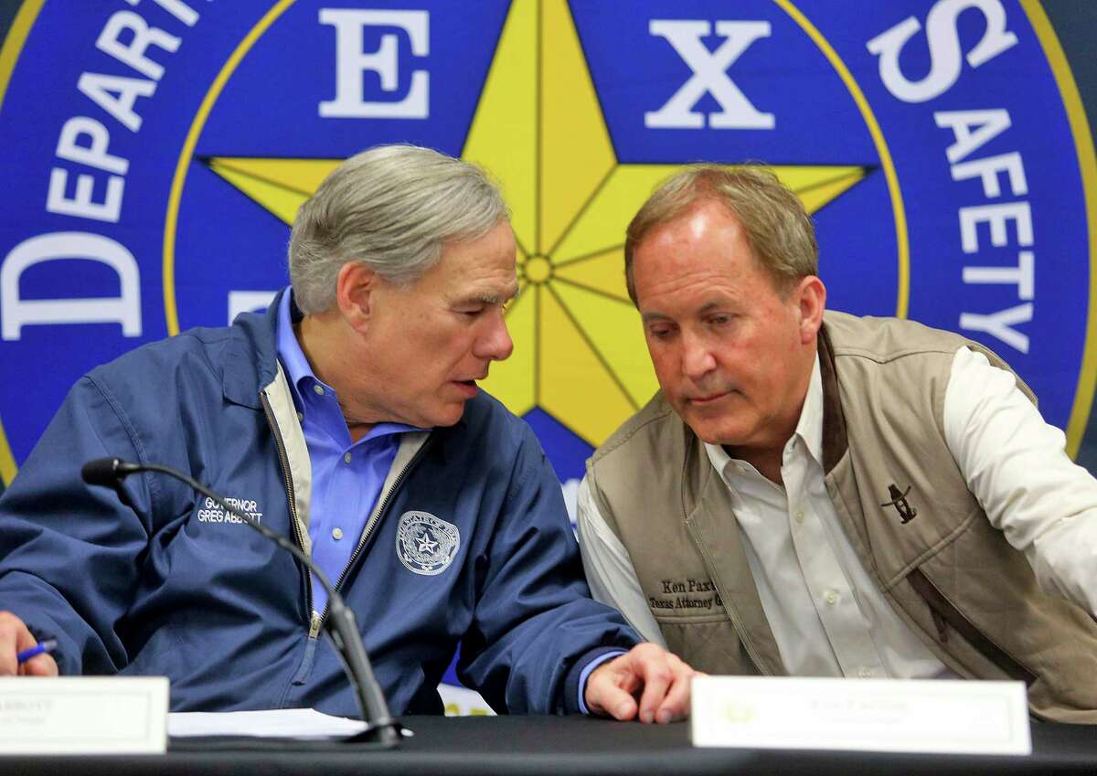 Texas Gov. Greg Abbott, left, and Texas Attorney General Ken Paxton confer during a conference after an Operation Lone Star roundtable discussion at the Texas Department of Public Safety Weslaco Regional Office on Thursday, March 10, 2022, in Weslaco, Texas.
