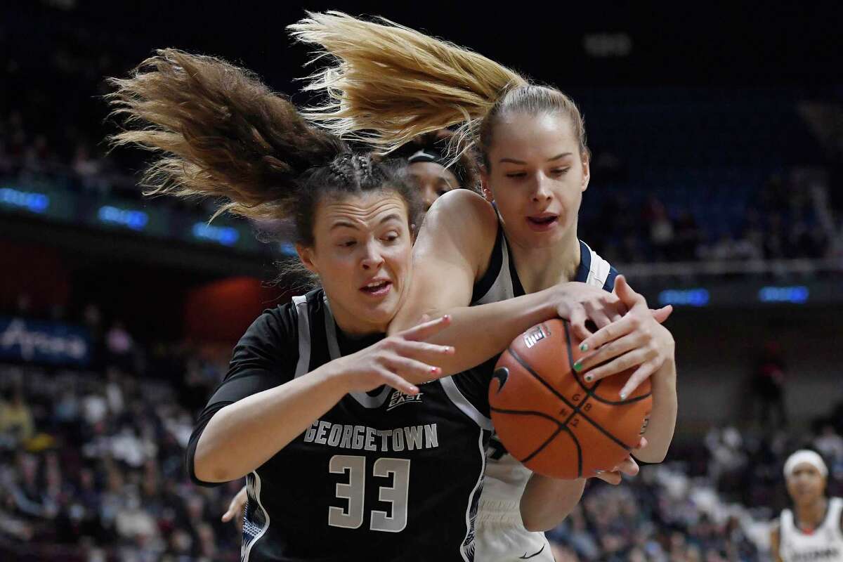 Connecticut's Dorka Juhász, right, grabs a rebound over Georgetown's Graceann Bennett first half of an NCAA college basketball game in the Big East tournament quarterfinals at Mohegan Sun Arena, Saturday, March 5, 2022, in Uncasville, Conn. (AP Photo/Jessica Hill)