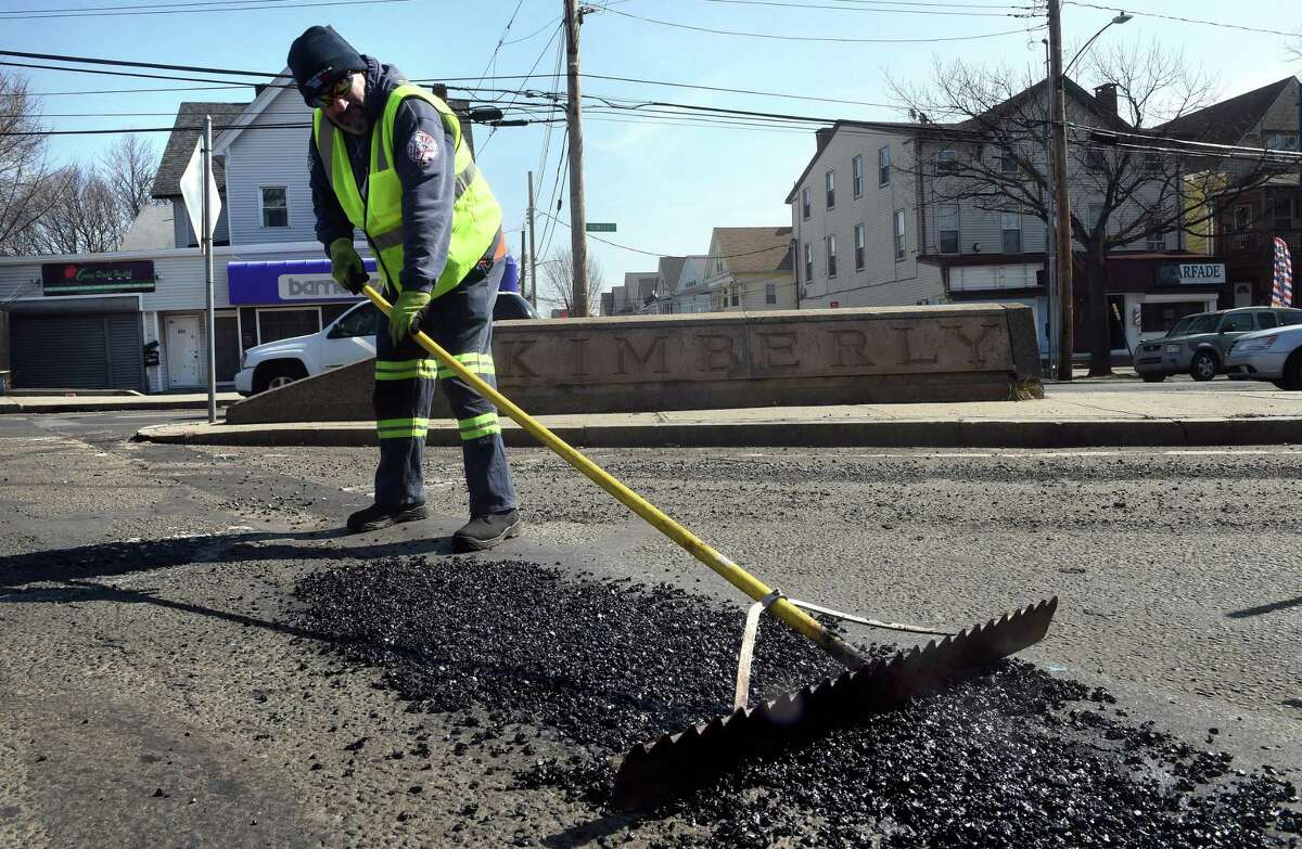 Scott Murphy of the New Haven Public Works Department patches a hole on Kimberly Avenue in New Haven on March 11, 2022.