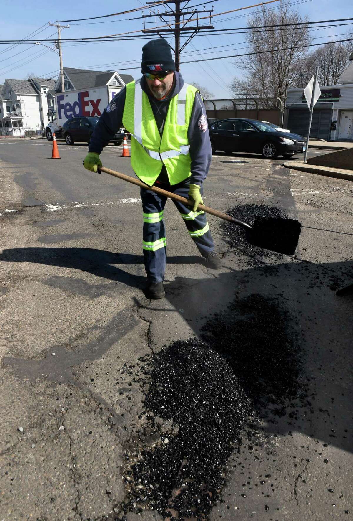 Scott Murphy of the New Haven Public Works Department patches a hole on Kimberly Avenue in New Haven on March 11, 2022.