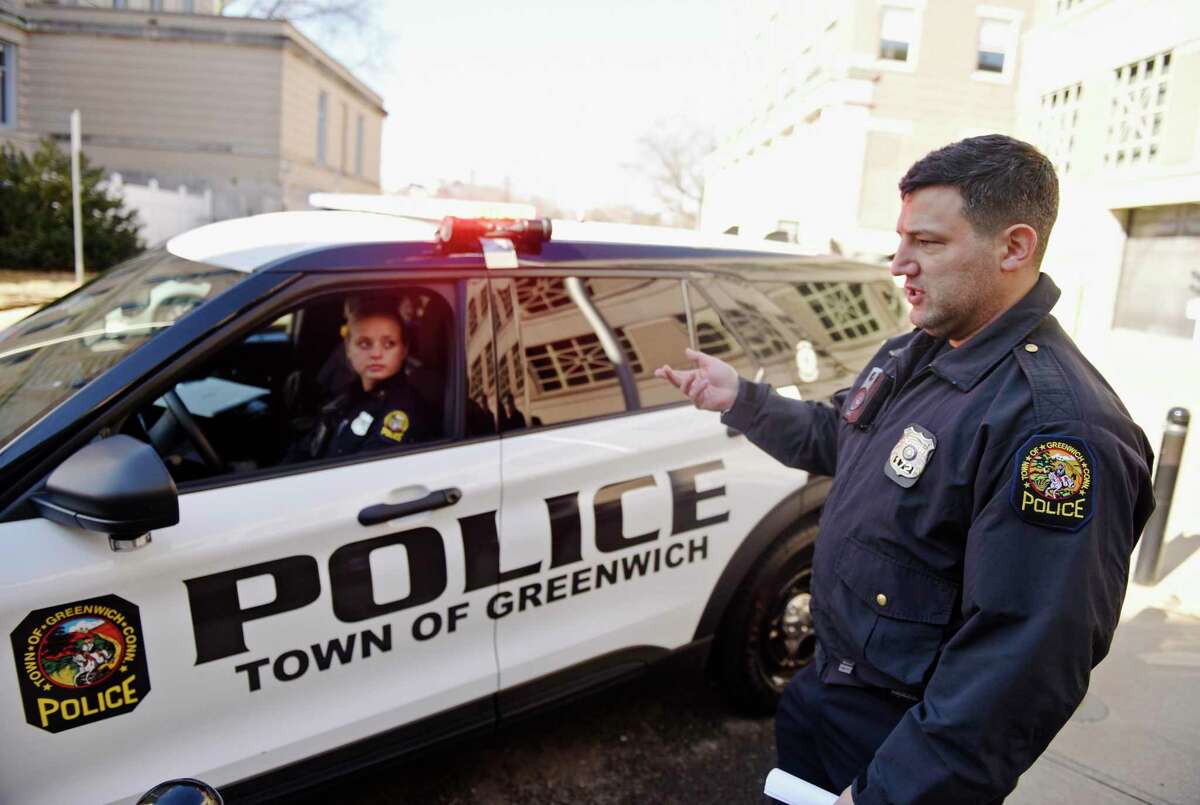 Patrol Officers Kassidy Schupp and Matthew Swift show a new hybrid police cruiser outside the Public Safety Complex in Greenwich, Conn. Tuesday, March 3, 2022. The Greenwich Police Department recently added four hybrid Ford Explorers to its fleet, marking the first hybrid vehicles to be used by GPD.