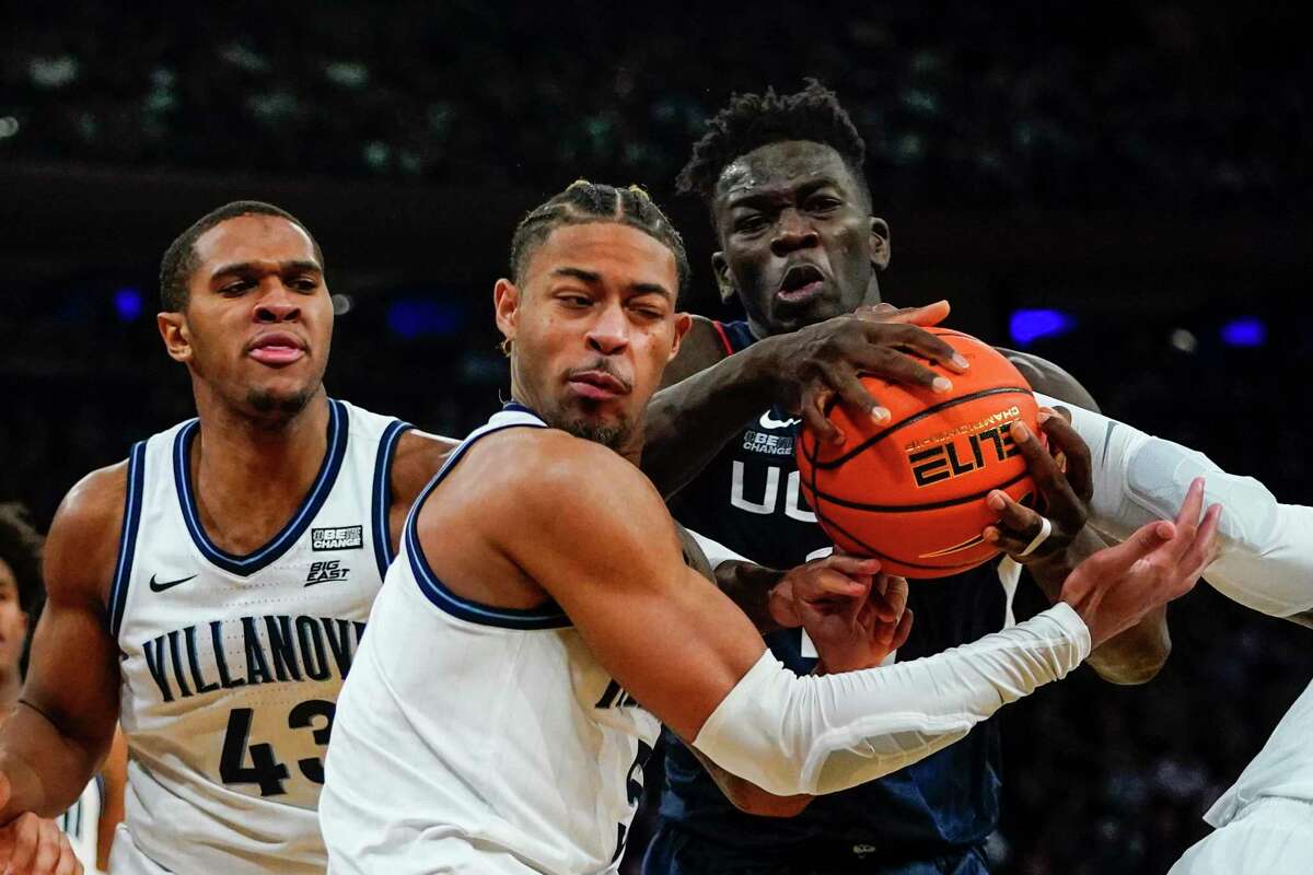Villanova's Justin Moore (5) fights for control of the ball with Connecticut's Adama Sanogo (21) during the second half of an NCAA college basketball game in the semifinal round of the Big East conference tournament Friday, March 11, 2022, in New York. (AP Photo/Frank Franklin II)