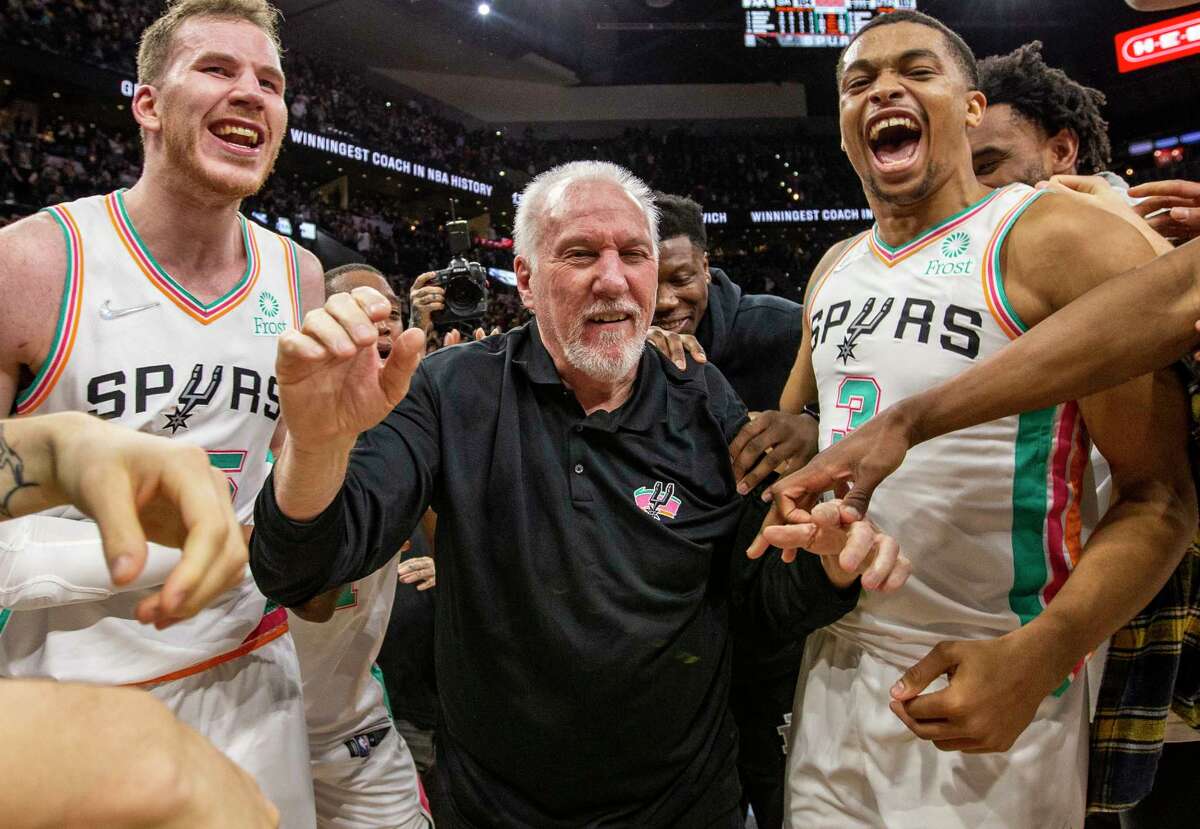 San Antonio Spurs head coach Gregg Popovich celebrates Friday, Mar 11, 2022 at the AT&T Center in San Antonio with San Antonio Spurs center Jakob Poeltl (25), left, and San Antonio Spurs forward Keldon Johnson (3) after the Spurs beat the Utah Jazz 104-102 to give Popovich 1,336 regular season wins, the most in NBA history.