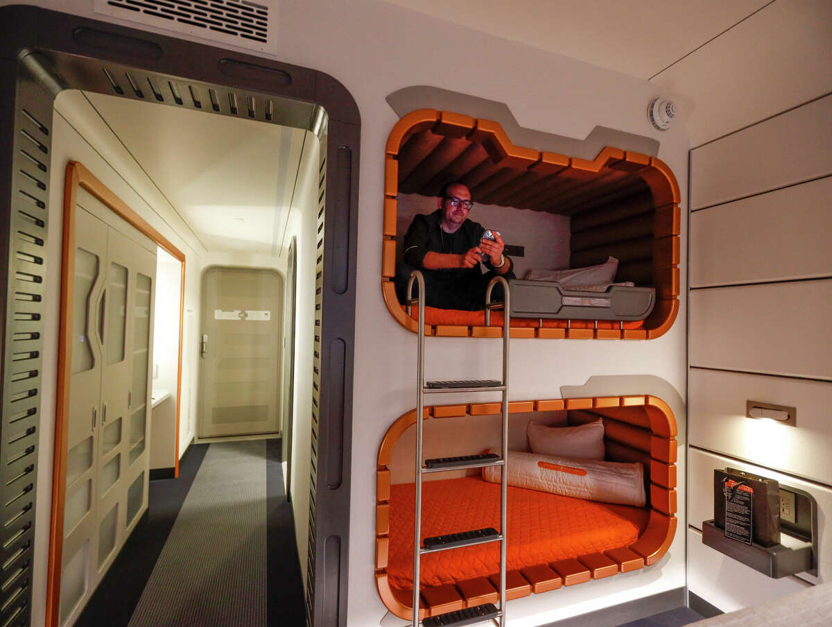 Los Angeles Times columnist Todd Martens sits in one of the bunk beds inside a room in Walt Disney World's Star Wars: Galactic Starcruiser on March 1.