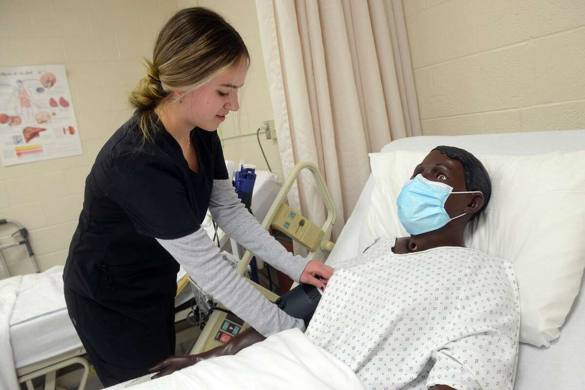 Grace McPadden works with a medical mannequin during her fundamentals of health science class on March 3.
