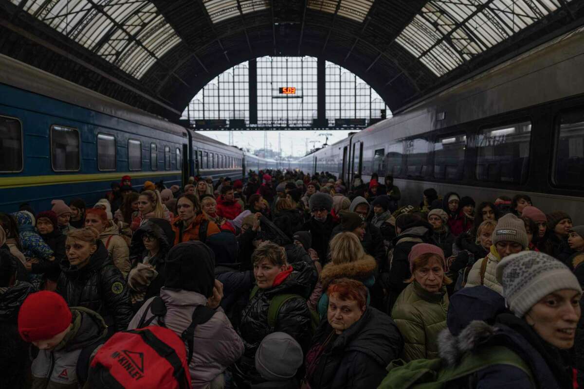 Families make their way from the main train terminal March 5 in Lviv, Ukraine, many on their way to Poland.