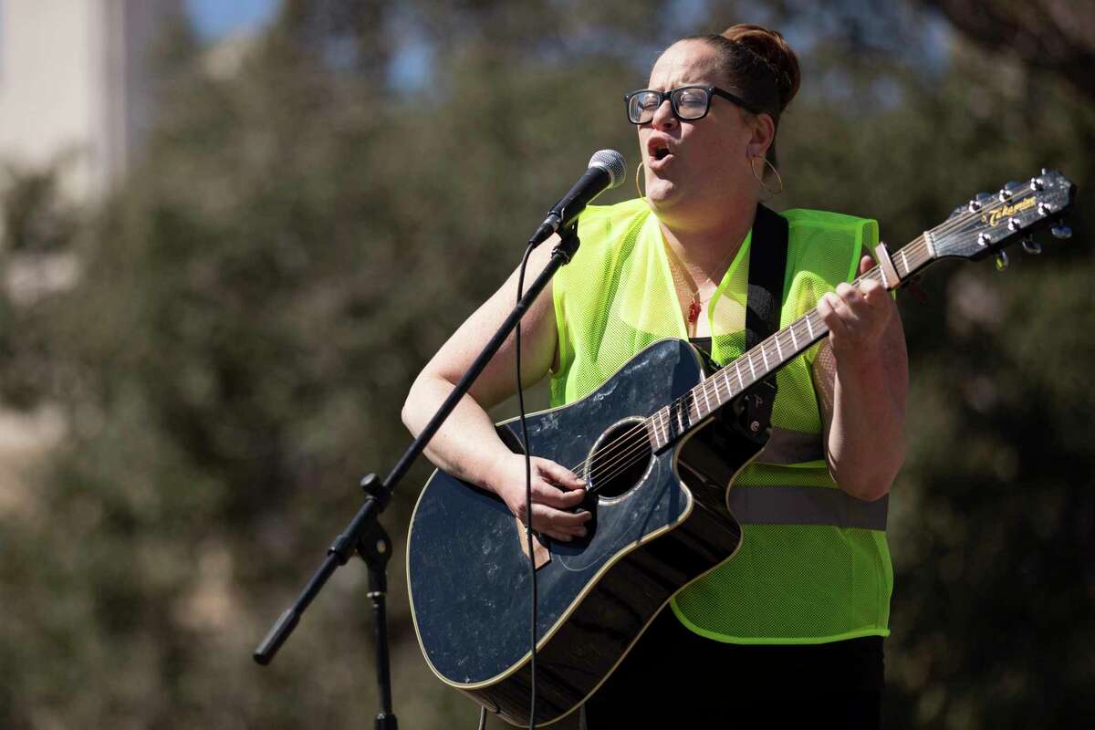 Jules Vaquera of San Antonio sings a song she wrote titled “Speak Up” during the San Antonio International Women’s Day March & Rally held at Travis Park on Saturday, March 12, 2022.