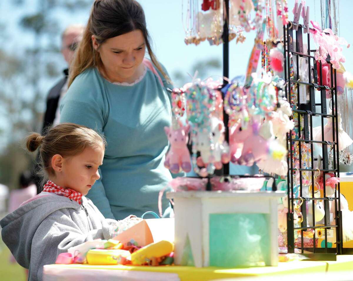 Aurelia Pitarra, left, looks at jewelry with her mother, Wendy, during Arts in the Park at Northshore Park, Saturday, March 12, 2022, in The Woodlands. The annual free event featured local vendors with original artwork, live ,music and children’s activities.