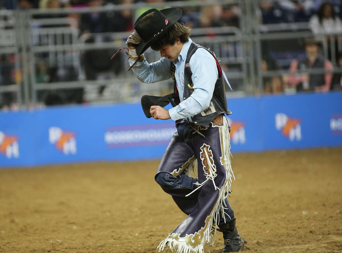 Cole Reiner, representing RODEOHOUSTON, picks up his hat after competing in bareback riding the Super Shootout at the Houston Livestock Show and Rodeo Saturday, March 12, 2022, at NRG Stadium in Houston.