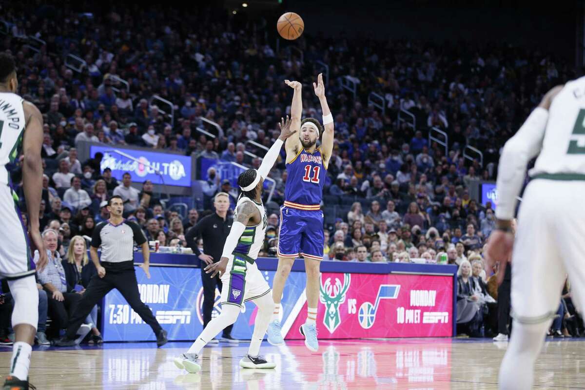Golden State Warriors guard Klay Thompson (11) scores a three-point shot against the Milwaukee Bucks in the second half of an NBA game at Chase Center, Saturday, March 12, 2022, in San Francisco, Calif.