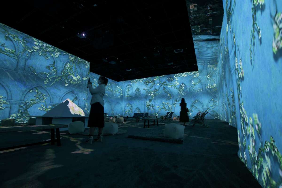 People watch a portion of the 360 degree immersive show depicting Van Gogh’s life through his art in the Van Gogh Immersive art exhibit in the MarqE Entertainment Center on Friday, Sept. 17, 2021, in Houston, Texas.