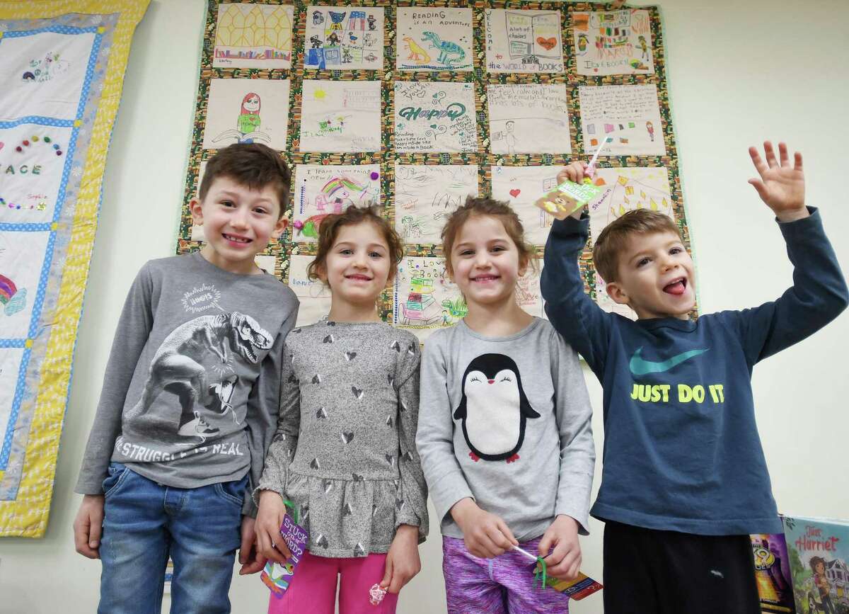 From left; Siblings Landon, 7, and triplets Riley, Micha, and Hudson Rarey, 4, each produced a panel for the Plumb Memorial Library's Children's Quilt, each expressing love of the library and books, in Shelton, Conn., on Saturday, March 12, 2022.