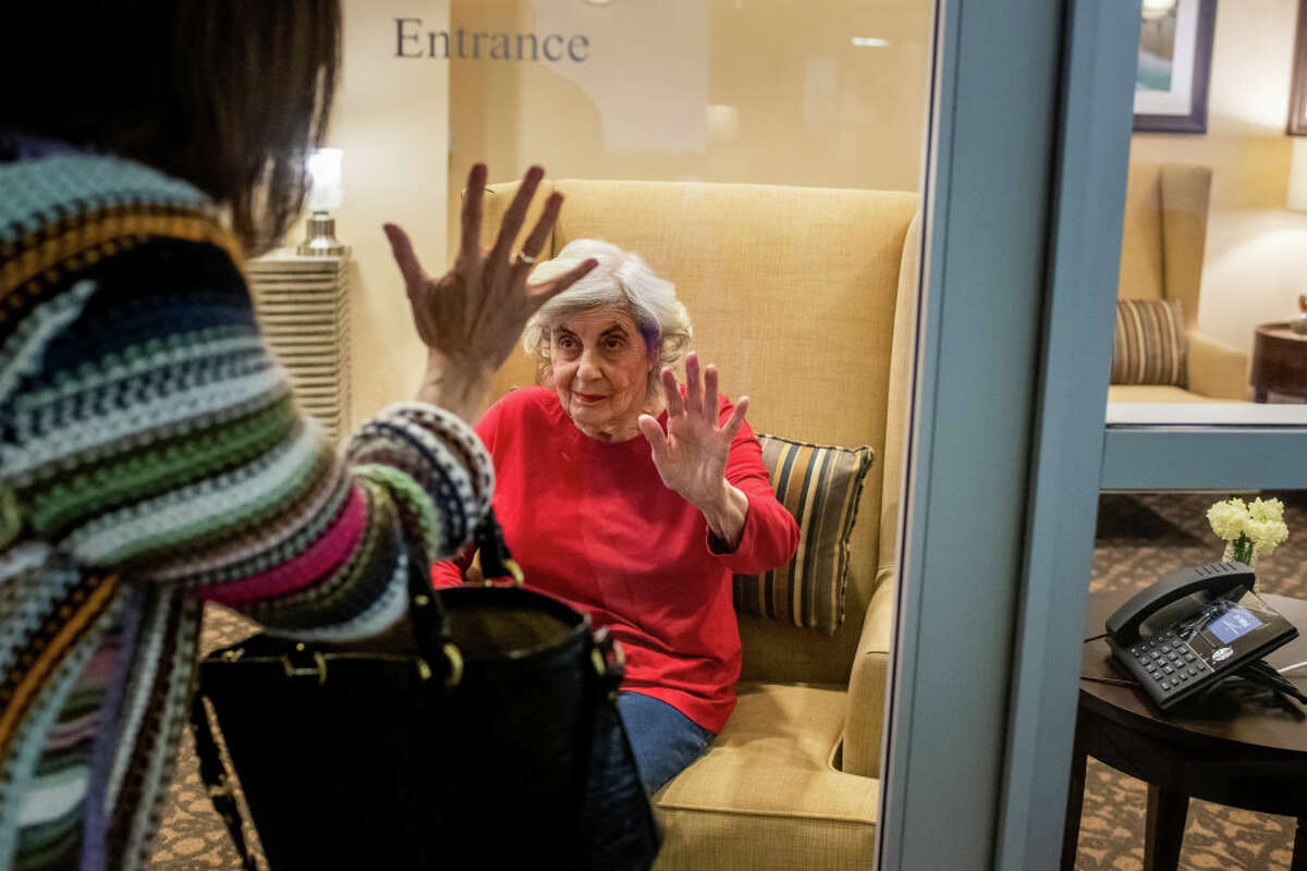 Karen Klink visits her 86-year-old mother, Cynthia Tachner, at a nursing home last year. Most nursing homes closed access by visitors, including family members, during the height of the pandemic.