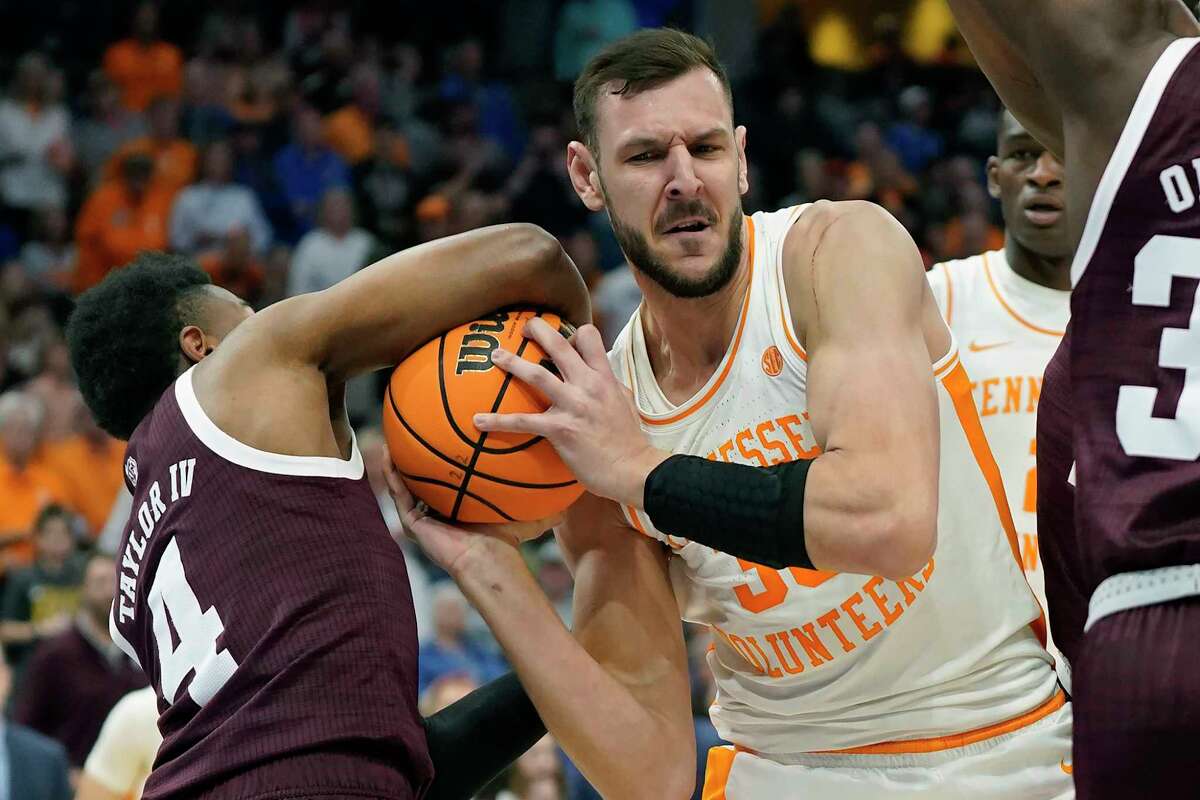 Tennessee forward Uros Plavsic (33) gets tied up by Texas A&M guard Wade Taylor IV (4) during the first half of an NCAA men's college basketball Southeastern Conference tournament championship game Sunday, March 13, 2022, in Tampa, Fla. (AP Photo/Chris O'Meara)