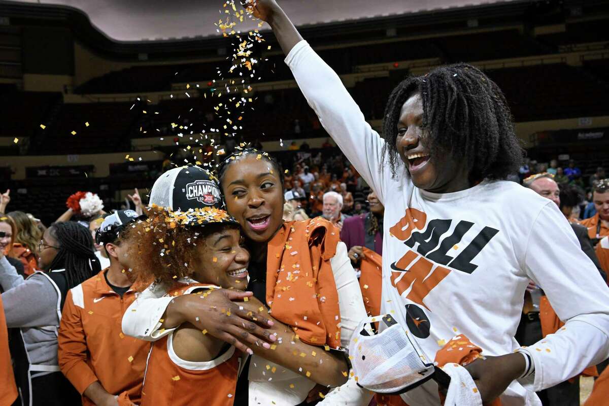 Texas guard Rori Harmon, lower left, is showered with confetti by teammate Femme Masudi while hugging associated head coach Dinah Jackson after the NCAA college basketball championship game against Baylor in the Big 12 Conference tournament in Kansas City, Mo., Sunday, March 13, 2022. Harmon won the "Outstanding Player" trophy for the tournament. (AP Photo/Reed Hoffmann)