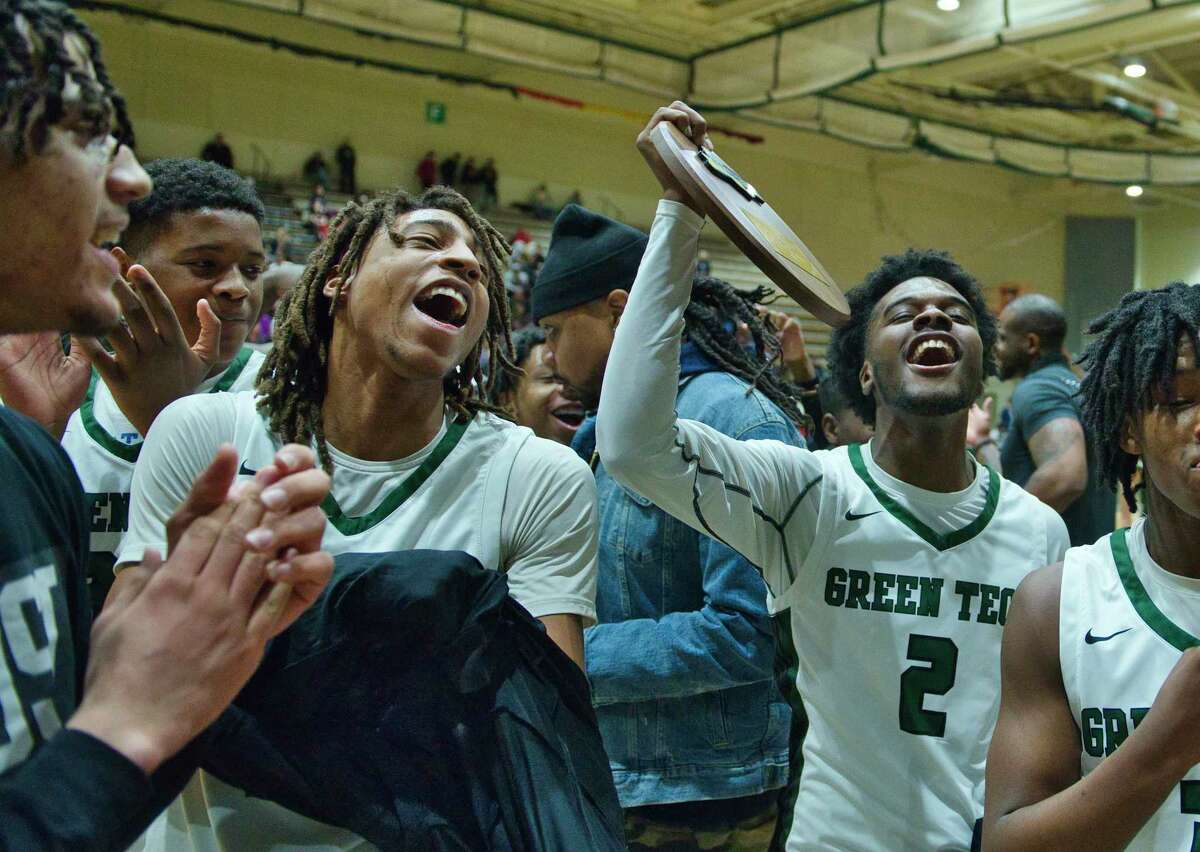 Zhaji Williams, right, of Green Tech holds their plaque as he and his teammates celebrate their win over Liverpool in their Class AA boys' basketball state quarterfinal game on Sunday, March 13, 2022, in Troy, N.Y.
