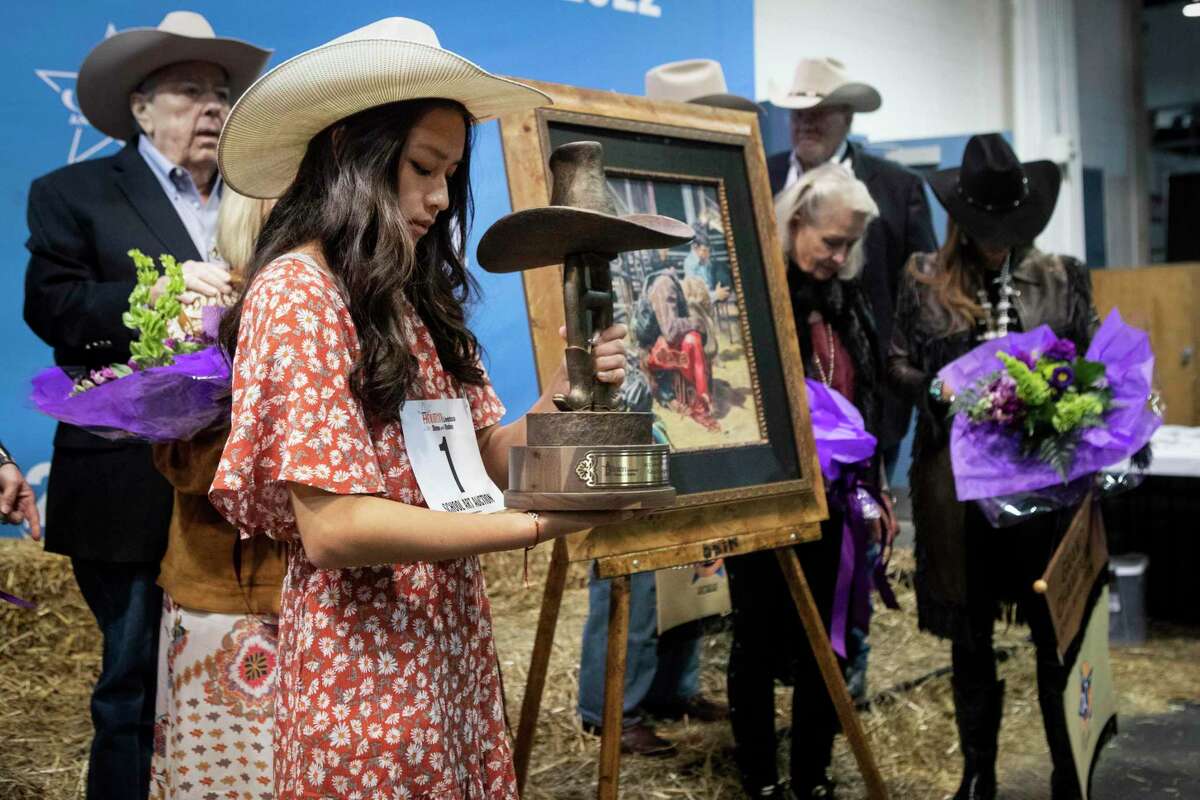 Dawson High School student Gracin Nguyen takes a look at the championship trophy for her artwork, a colored drawing titled “In His Hands,” during the school art auction at the 2022 Houston Livestock Show and Rodeo. Art from Nguyen will be among works displayed in this year's Pearland ISD Rodeo Art Exhibit, which will be Jan. 19 at  at Virgil Gant Education Support Center, 1928 N. Main, Pearland.